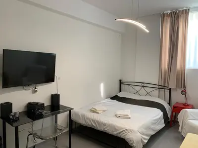 a bedroom with a bed and a flat screen tv at Holodek Apartments Ground & SemiBasement in Athens