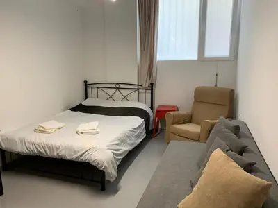 a small bedroom with a bed and a chair at Holodek Apartments Ground & SemiBasement in Athens
