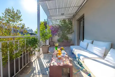 a patio with a couch and a table on a balcony at Hidesign Athens Luxury Apartments in Kolonaki in Athens