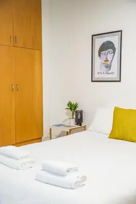 a bedroom with a bed with two white towels on it at Concierge Downtown in Athens