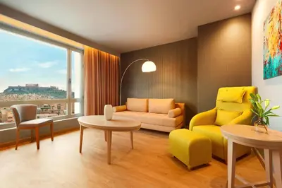 a living room with a yellow couch and a table at Zeus Wyndham Grand Athens in Athens