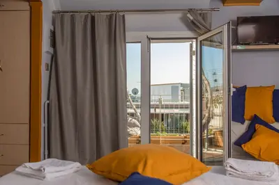 a bedroom with a bed and a large glass window at Studio Acropolis in Athens