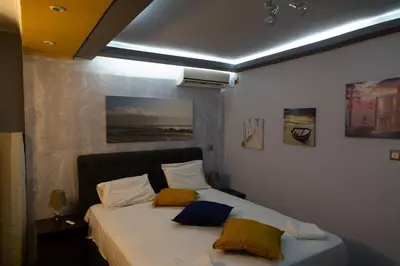 a bedroom with a bed with yellow and blue pillows at Studio Acropolis in Athens