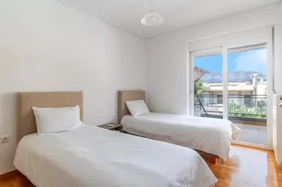 two beds in a room with a window at Elvita Spata Luxurious Villa in Spáta