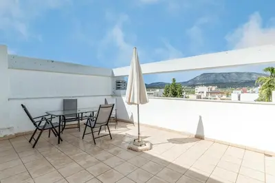 a patio with a table and chairs and an umbrella at Elvita Spata Luxurious Villa in Spáta