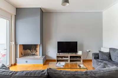 a living room with a couch and a tv at Elvita Spata Luxurious Villa in Spáta