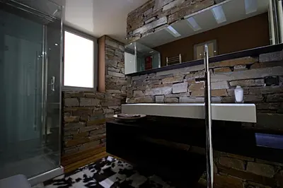 a bathroom with a sink and a stone wall at Panorama Penthouse & Studios in Athens