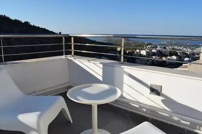 a stool on a balcony with a view of the city at Panorama Penthouse & Studios in Athens