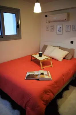 a bed with a book on it with a table on it at Panorama Penthouse & Studios in Athens