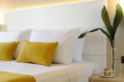 a bedroom with a white bed with yellow pillows at Athens Avenue Hotel in Athens