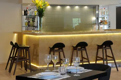 a bar with a table with wine glasses on it at Athens Avenue Hotel in Athens
