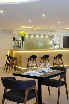 a restaurant with a table with wine glasses on it at Athens Avenue Hotel in Athens