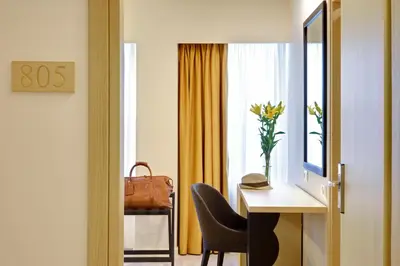 a room with a desk and a chair and a window at Athens Avenue Hotel in Athens