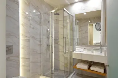 a bathroom with a glass shower and a sink at Athens Avenue Hotel in Athens