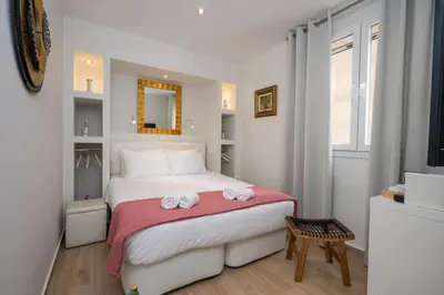 a white bedroom with a bed with towels on it at Dema Luxury Suites - Perikleous E1 in Athens