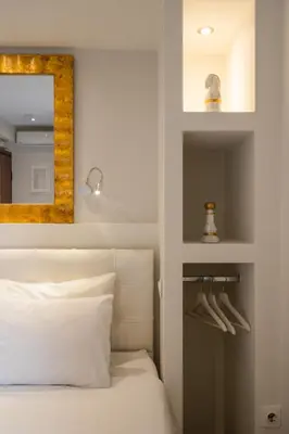 a bedroom with a white bed and a mirror at Dema Luxury Suites - Perikleous E1 in Athens