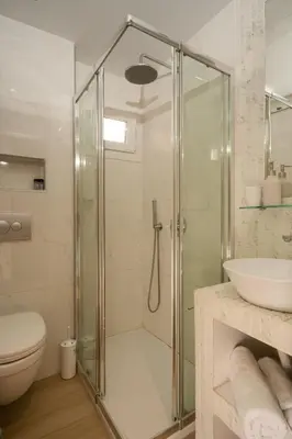 a bathroom with a shower and a toilet and a sink at Dema Luxury Suites - Perikleous E1 in Athens