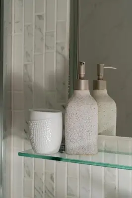 two bottles and a bowl on a glass shelf at Dema Luxury Suites - Perikleous E1 in Athens
