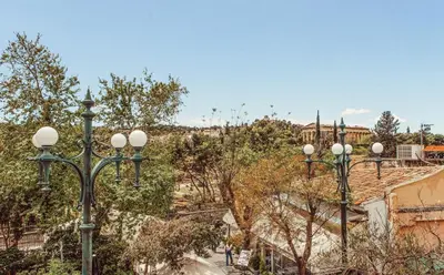 a row of street lights with a building in the background at Suitas in Athens