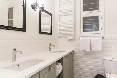 a white bathroom with two sinks and a toilet at 1930's Athenian House by YHA in Athens