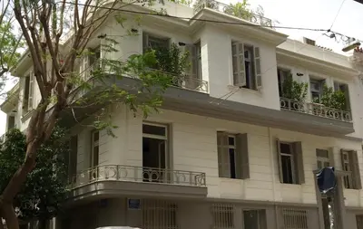 a white building with windows and a balcony at 1930's Athenian House by YHA in Athens