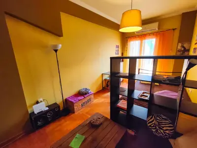 a living room with yellow walls and a table at Studio in Athens center in Athens