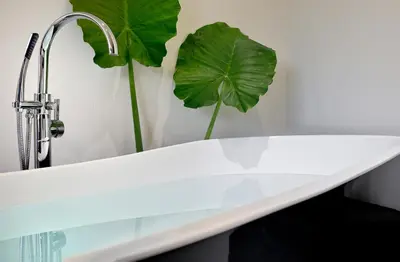 a white bath tub with a faucet and a plant at ALTO PSYRRI PENTHOUSE by K&K in Athens