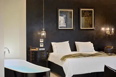 a bedroom with two beds and a table and a tub at ALTO PSYRRI PENTHOUSE by K&K in Athens