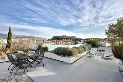 a patio with a table and chairs on a roof at ALTO PSYRRI PENTHOUSE by K&K in Athens