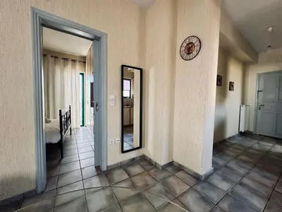 a hallway with a mirror and a clock on a wall at Cozy Apartments Mc Queen in Athens