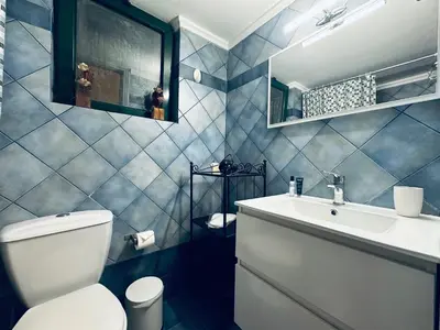a bathroom with a white toilet and a sink at Cozy Apartments Mc Queen in Athens