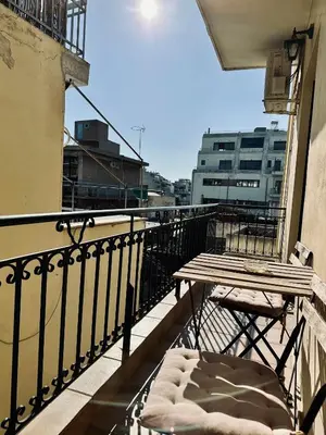 a balcony with a table and a bench on a balcony at Cozy Apartments Mc Queen in Athens