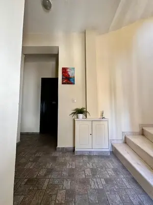 a hallway with stairs and a table with a plant on it at Cozy Apartments Mc Queen in Athens