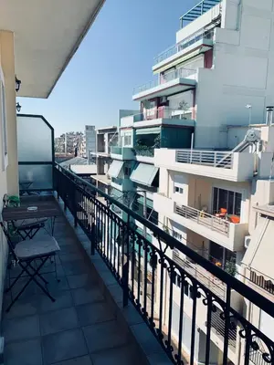 a balcony of a building with a table and chairs at Cozy Apartments Mc Queen in Athens