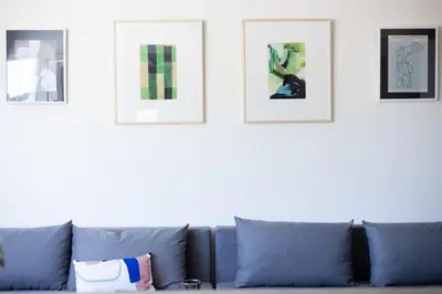 a blue couch in a living room with pictures on the wall at 3 bdr Apt Incredible Acropolis View in Athens