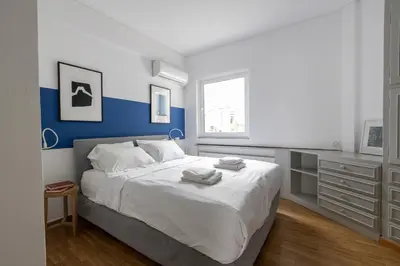 a bedroom with a bed with a blue and white wall at Deco Marble Apt with Acropolis view in Athens