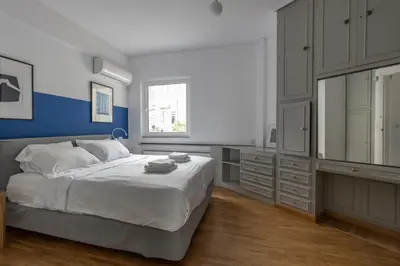 a bedroom with a large white bed and a window at Deco Marble Apt with Acropolis view in Athens