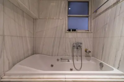 a white bath tub in a bathroom with a window at Deco Marble Apt with Acropolis view in Athens