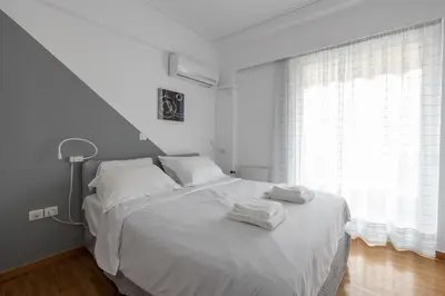 a bedroom with a white bed with towels on it at Deco Marble Apt with Acropolis view in Athens