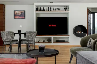 a living room with a tv and a table and chairs at Blazer Suites Hotel in Athens