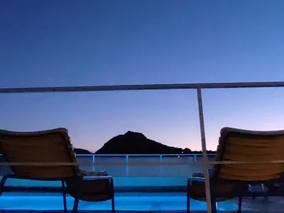 two chairs sitting on a roof with a view of a mountain at Galini Hotel in Agia Marina Aegina