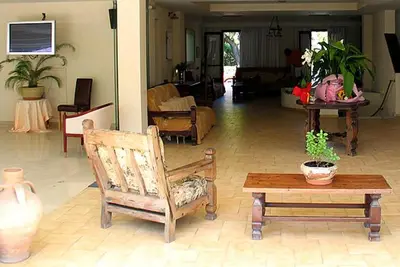 a living room with a chair and a table at Galini Hotel in Agia Marina Aegina