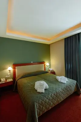 a hotel room with a bed with two towels on it at Athens Mirabello in Athens