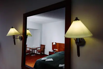 a bedroom with a mirror and a bed and a table at Athens Mirabello in Athens