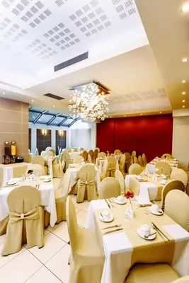 a dining room with white tables and chairs at Athens Mirabello in Athens