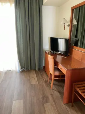 a room with a desk with a television and a mirror at Athens Mirabello in Athens