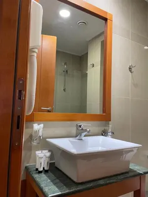 a bathroom with a white sink and a mirror at Athens Mirabello in Athens