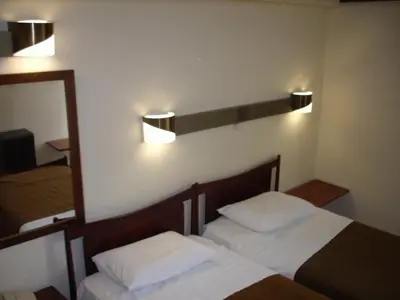 a bedroom with two beds and a mirror and lights at Claridge Hotel in Athens