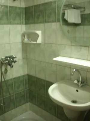 a bathroom with a shower and a sink and a mirror at Claridge Hotel in Athens