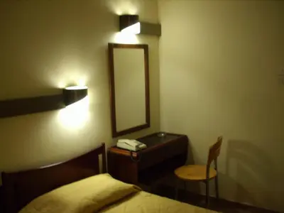 a bedroom with a mirror and a bed and a chair at Claridge Hotel in Athens